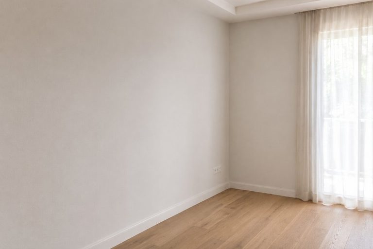 Habitación con pared completamente lisa lista para pintar tras retirada profesional del gotelé