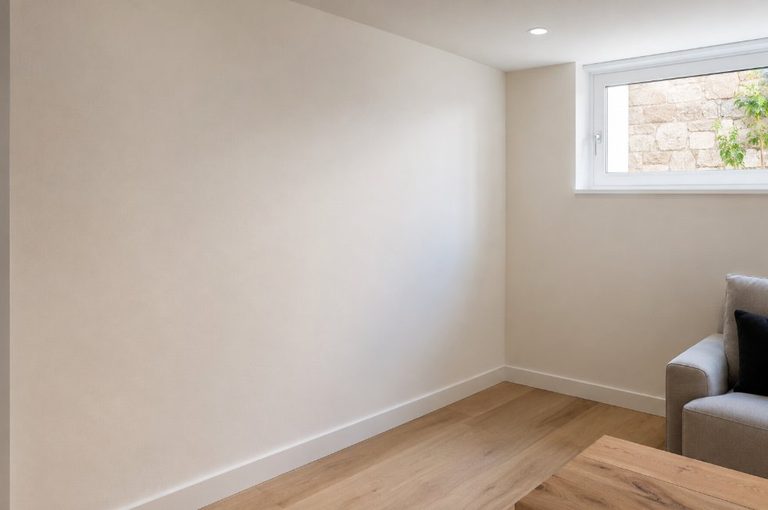 Habitación con la pared seca y repintada tras la eliminación completa de la humedad por capilaridad